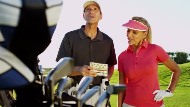 Graczy płci męskiej i żeńskiej golfa na polu golfowym — Wideo stockowe