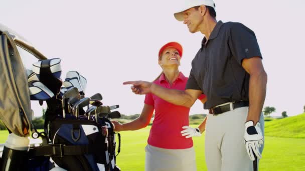 Mannelijke en vrouwelijke golfspelers op golfbaan — Stockvideo