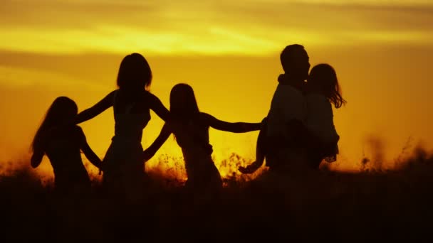 Parents avec leurs filles dans la prairie au coucher du soleil — Video