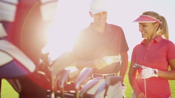 Чоловічі та жіночі гравці в гольф на полі для гольфу — стокове відео