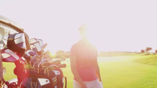 Golfspeler met golfclubs outdoors — Stockvideo