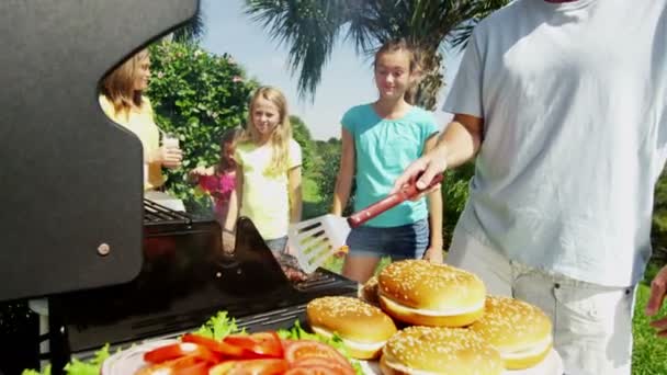 Ouders met dochters grillen van vlees van de barbecue — Stockvideo