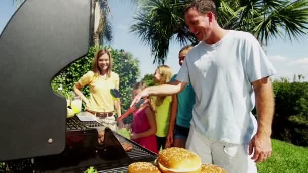 Ouders met dochters grillen van vlees van de barbecue — Stockvideo