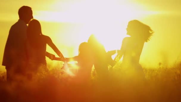 Γονείς με κόρες στο Λιβάδι στο ηλιοβασίλεμα — Αρχείο Βίντεο
