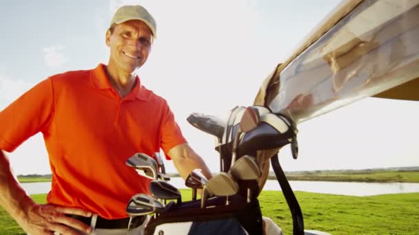 Professional male golf player and golf cart with equipment — Stock Video