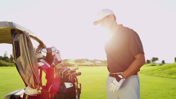 Golf player with golf clubs outdoors — Stock Video