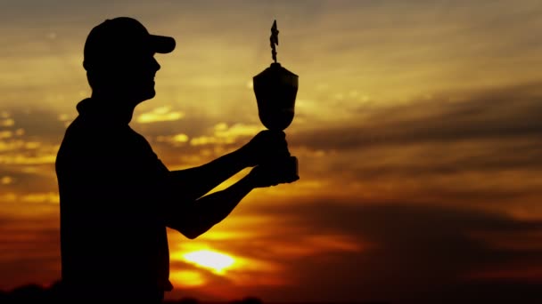 Силуэт профессионального гольфиста с трофеем — стоковое видео