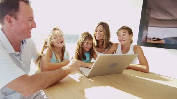 Батьки з дітьми використовують ноутбук на яхті — стокове відео