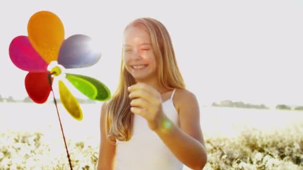 Дівчина на відкритому повітрі грає з барвистою іграшкою вітряної млини — стокове відео