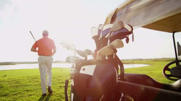 Jogador de golfe masculino profissional e carrinho de golfe com equipamento — Vídeo de Stock