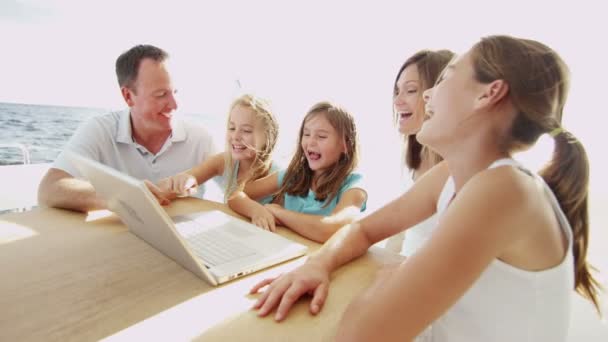 Parents with children using laptop on yacht — Stock Video