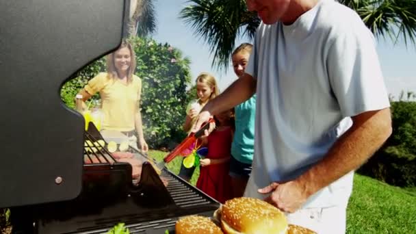 Eltern mit Töchtern grillen Grillfleisch — Stockvideo