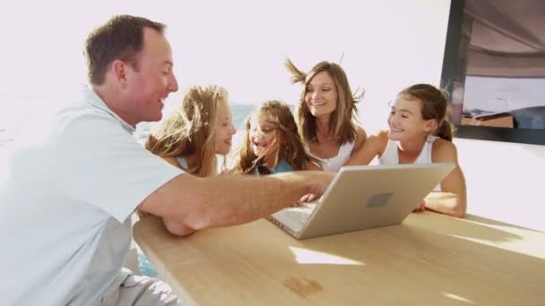 Батьки з дітьми використовують ноутбук на яхті — стокове відео