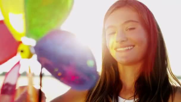 Dívka si hraje s hračkou barevné větrný mlýn — Stock video