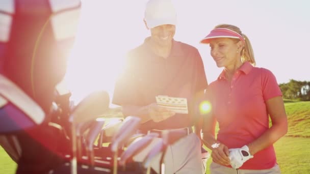 Mannelijke en vrouwelijke golfspelers op golfbaan — Stockvideo