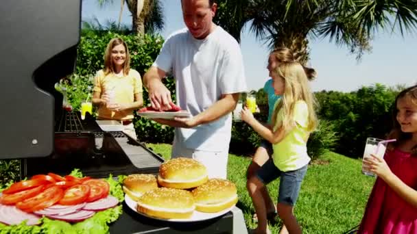 Ouders met dochters grillen van vlees van de barbecue — Stockvideo