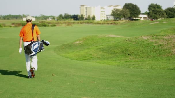 Golfspeler wandelen met golfuitrusting — Stockvideo