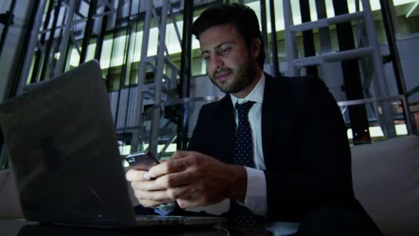 Affärsman arbetar med laptop och smarta telefonen på natten — Stockvideo