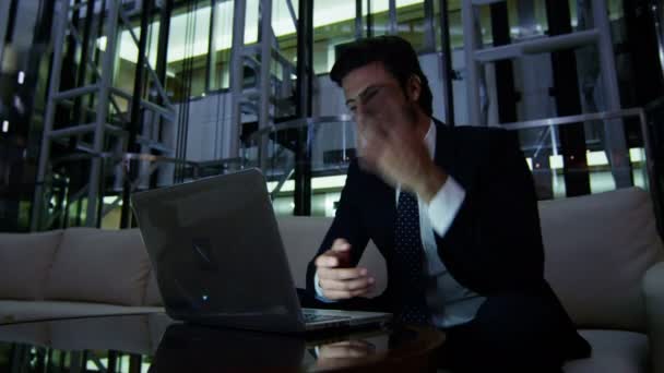 Zakenman die werken met de laptop en smartphone bij nacht — Stockvideo