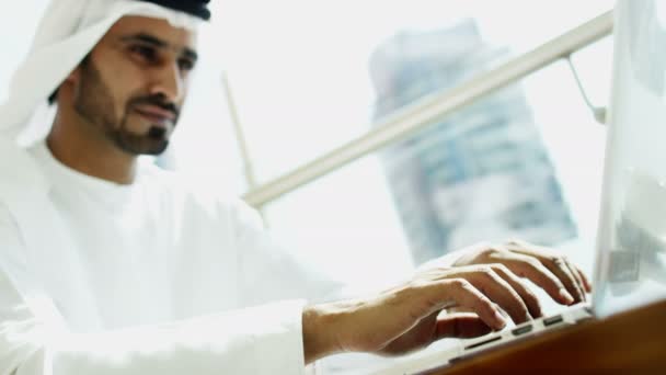 Businessman in traditional dress working on laptop — Stockvideo