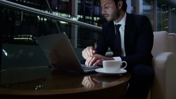 Homem de negócios trabalhando com laptop e telefone inteligente à noite — Vídeo de Stock