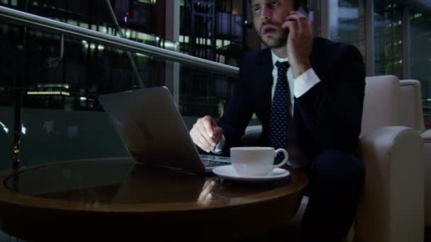 夜にノート パソコンやスマート フォンを操作するビジネスマン — ストック動画