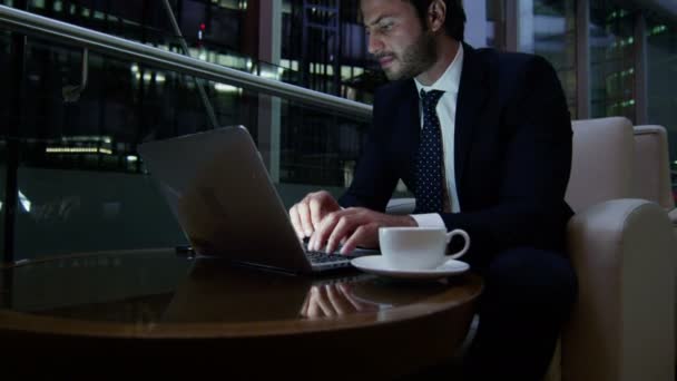 Homem de negócios trabalhando com laptop e telefone inteligente à noite — Vídeo de Stock