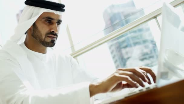 Businessman in traditional dress working on laptop — Stockvideo