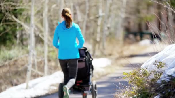 Mamma med son i sittvagn i park — Stockvideo