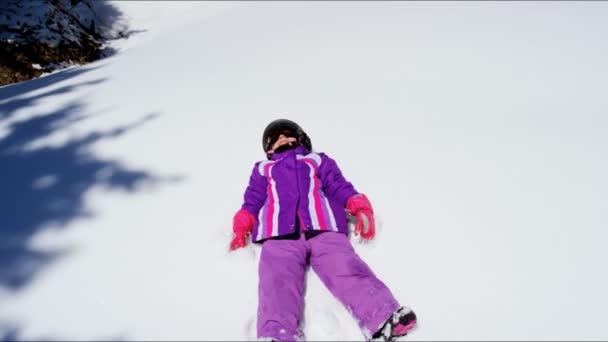 Kleine meisje maken sneeuw engel — Stockvideo