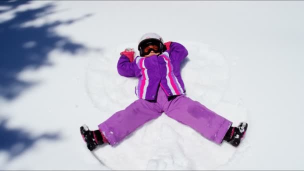 Little girl making snow angel — Stock Video