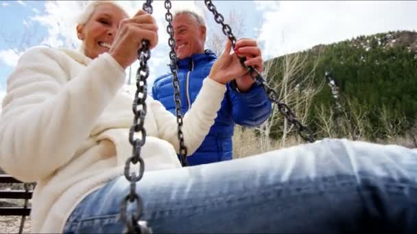 Senior couple balançant sur une balançoire à l'extérieur — Video