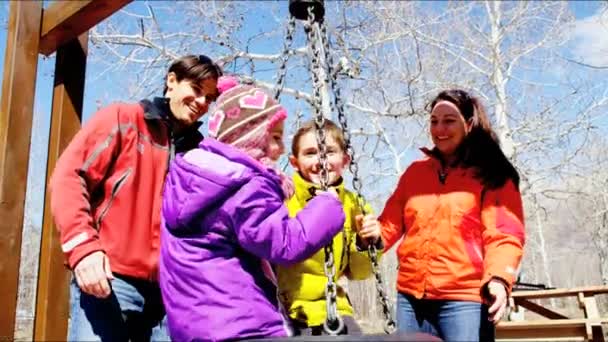 Familj med barn att ha kul på swing — Stockvideo