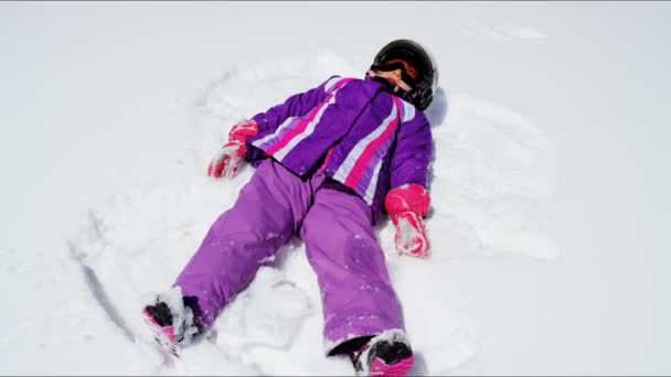 Niña haciendo ángel de nieve — Vídeos de Stock