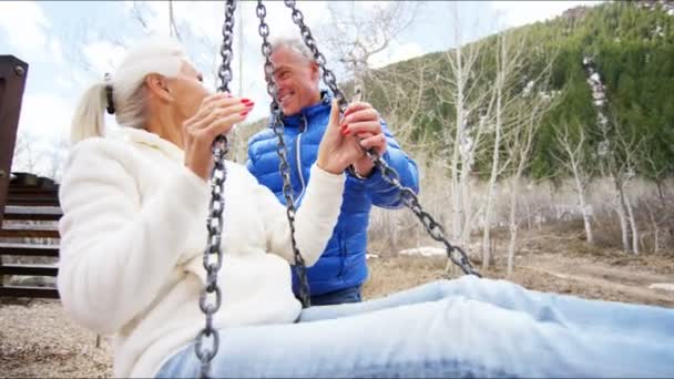 Senior couple balançant sur une balançoire à l'extérieur — Video