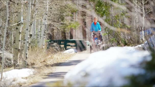 Mamma med son i sittvagn i park — Stockvideo