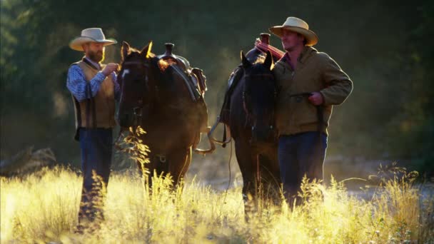 Cavaleiros de vaqueiro com cavalos em montanhas rochosas — Vídeo de Stock