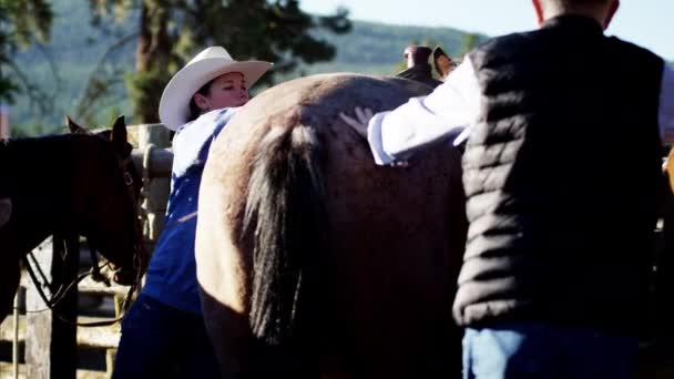 Cowgirl saddling horse — Stock Video