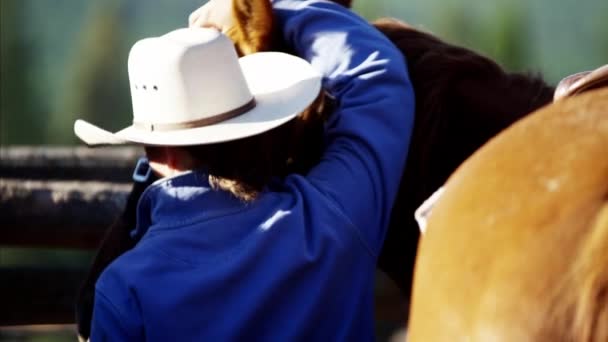 Cowgirl zadelen paard — Stockvideo