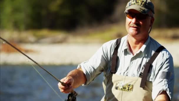 Fisherman using fly fishing reel — Stock Video