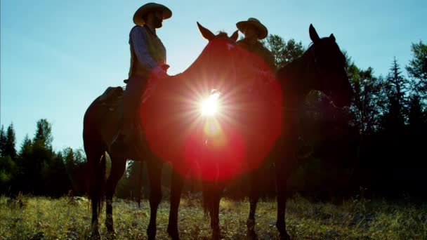 Cowboy Cavalieri a cavallo a valle — Video Stock