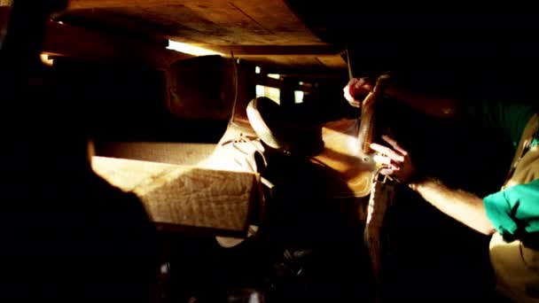 Ковбой з сідлом в сараї — стокове відео