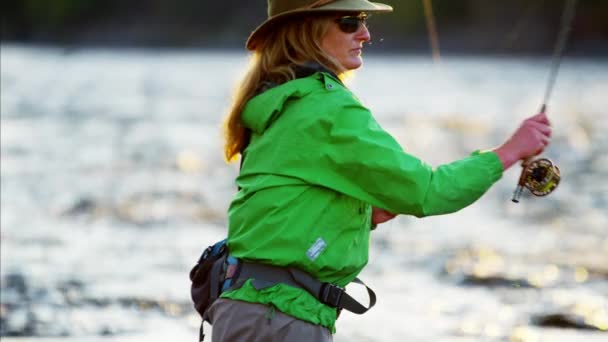 Female casting line in freshwater river — Stock Video