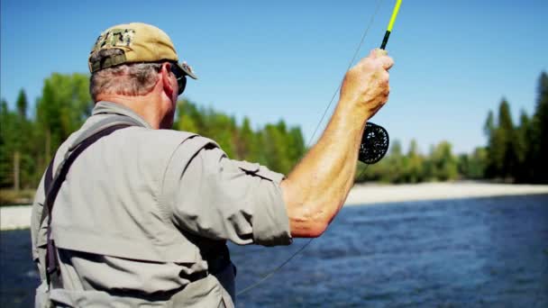 Рибалка використовує стрижень і котушку лиття лінії — стокове відео