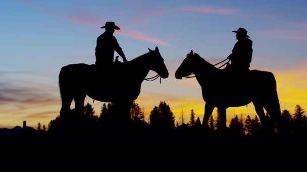 Cowboy Jinetes en el desierto al atardecer — Vídeos de Stock