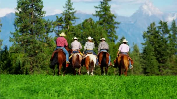 Cowboys e Cowgirls galopando em Mountain Range — Vídeo de Stock