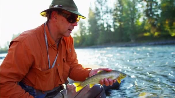 Fisherman with catch in keep net — Stock Video