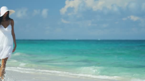 Žena v šatech bílým sluncem na pláži u oceánu — Stock video