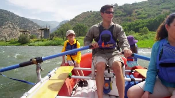 Родители и дети сплавляются по реке — стоковое видео