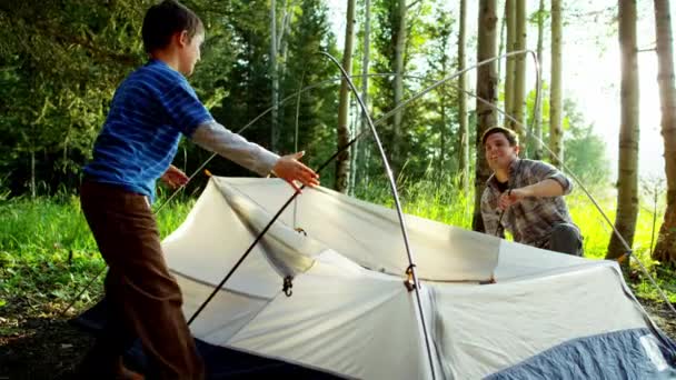 Père et fils érigeant la tente — Video